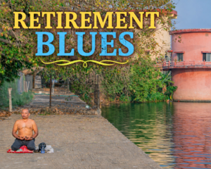 A man sits cross-legged in meditation on a concrete platform beside a calm water body, with trees and a cylindrical building reflected in the water.